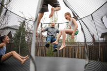 Father And Children Playing On Trampoline