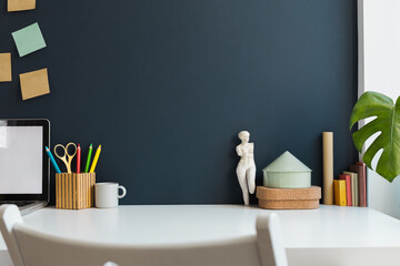 Wall Mural - Workspace with empty desk, laptop and dark blue wall. Homeschooling concept. Trendy, creative desk.