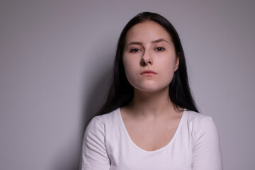 Close up portrait of pretty confident pensive thoughtful girl, looking seriously brunette. on grey background with copy space. People lifestyle concept