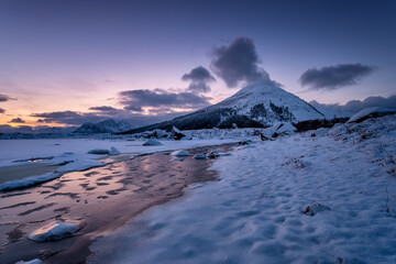 Wall Mural - lofoten islands, norway. mountains, ice with snow and clouds during sunset. evening time. winter lan