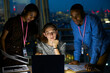 © Chris Ryan/Caia Image - Business people working late at laptop in office