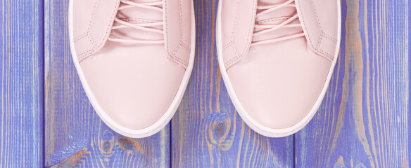 Pair of pink womanly leather shoes on old boards