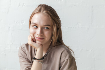 Young smiling blond girl, close-up studio portrait