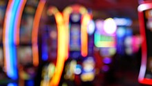 Defocused Slot Machines Glow In Casino On Fabulous Las Vegas Strip, USA. Blurred Gambling Jackpot Slots In Hotel Near Fremont Street. Illuminated Neon Fruit Machine For Risk Money Playing And Betting