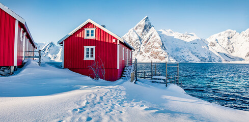 Canvas Print - Red wooden houses on the shore of Norwegian sea. Bright winter view of Hamnoy village, Lofoten Islands. Beautiful morning scene of Norway, Europe. Life over polar circle.