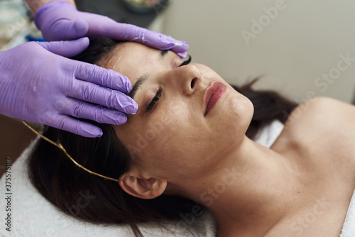 Fotografía Young woman having anti-stress facial massage in salon at spa resort