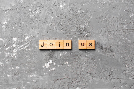 Join us word written on wood block. Join us text on cement table for your desing, Top view concept