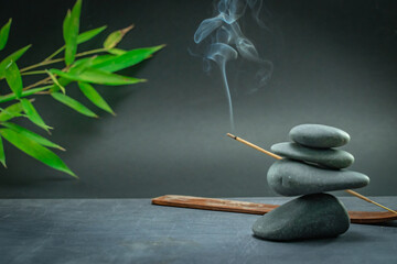 Spa zen basalt stones and green bamboo leaves on white background. The concept of wellness, relaxation, massage and well-being. Still life background. Harmony and balance.