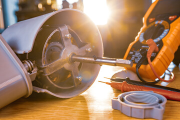 Wall Mural - Close-up of iron motor from home cooling fan lies on a table under repair