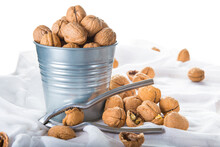Bucket Full Of Walnuts With A Nutcracker On A White Background