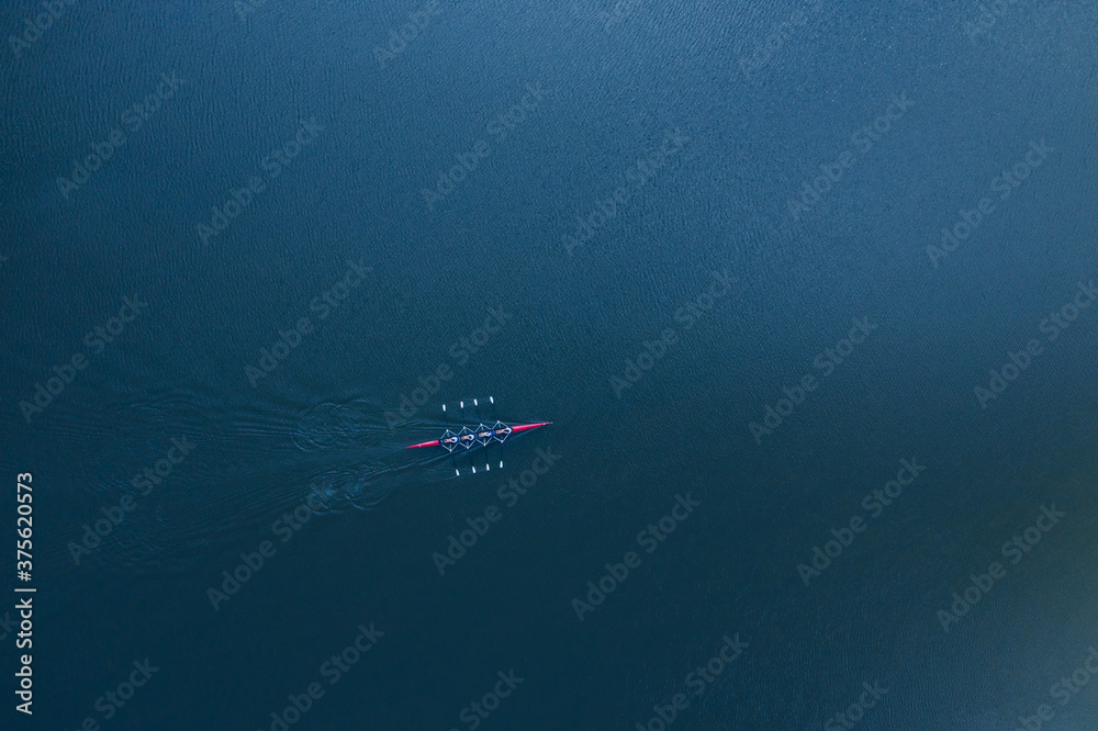 Boat coxed four rowers rowing on the blue river aerial drone top view - obrazy, fototapety, plakaty 