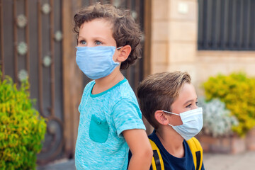 Wall Mural - Kids with medical face mask staying outdoor. Coronavirus protection.