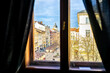 Lviv, Ukraine view of historic Ukrainian city in old town market rynok square with stores and people walking in winter on sunny sunset through window framing