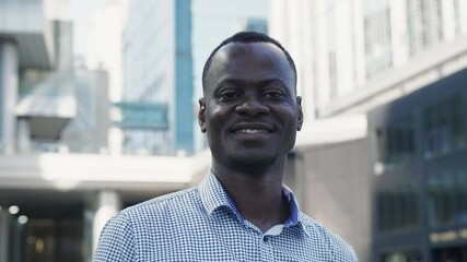 Wall Mural - portrait of happy African businessman looking at camera smile with urban office background