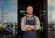 © Prins Productions - Smiling white male owner standing outside coffee shop cross armed.