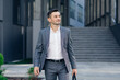 © uflypro - Modern businessman. Confident young man in suit looking away while standing outdoors with cityscape in the background. Handsome confident businessman portrait.