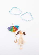A Girl With Colored Umbrella Under The Clouds And The Sun. Hand Made Of Paper Quilling Technique.