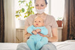 © Алина Троева - Beautiful mother in protective face mask holding her little cute newborn son protecting him from viruses and infections. Coronavirus covid-19 prevention. Home quarantine. Happy family at home.