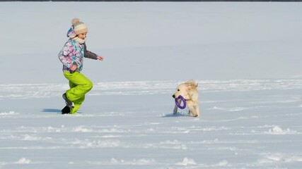 Canvas Print - Happy girl chasing cute dog in sparkling snow