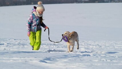 Canvas Print - Active winter walk of beautiful girl and playful dog