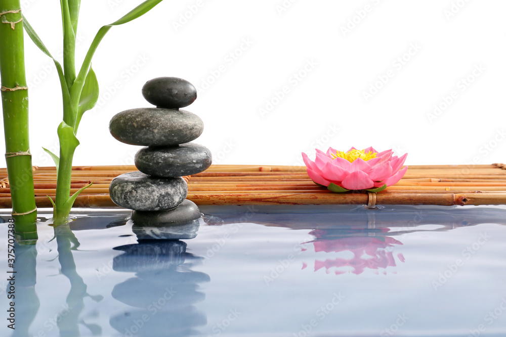 Stack of spa stones and bamboo in water on white background