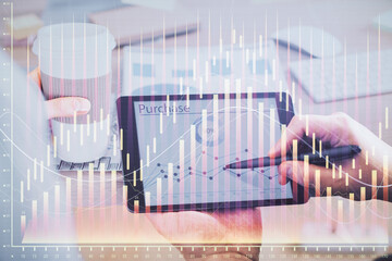 Double exposure of man's hands holding and using a phone and financial chart drawing. Market analysis concept.