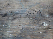 Face Of A Girl Etched Into A Wooden Picnic Table