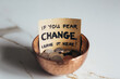 © Gourmet Photography/Stocksy - Copper bowl with coins with sign 'If you fear change, leave it here'