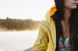 © HOWL/Stocksy - Young girl on a lake in a yellow raincoat, misty fog in the background