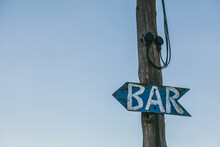 Old Bar Arrow Sign On A Wooden Post