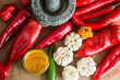 © Lior + Lone/Stocksy - Peppers, garlic and chilies next to mortar and pestle