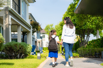 Happy Asian mother and daughter primary school student walking to school in the morning school routine for day in the life getting ready for school.