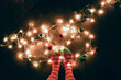 © Carolyn Lagattuta/Stocksy - Green and Red striped knee high socks and party lights