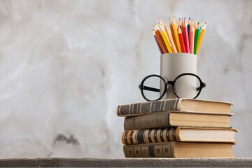 Wall Mural - A stack of books with glasses and pencils on the desk