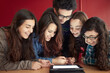 © MIQUEL LLONCH/Stocksy - Group of teenagers working with a digital tablet
