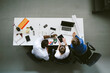 © simon/Stocksy - Young business people working - overhead