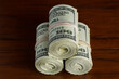 © David Smart/Stocksy - Three rolls of US one hundred dollar bills