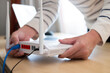 © BritCats Studio - Selective focus at router. Internet router on working table with blurred man connect the cable at the background. Fast and high speed internet connection from fiber line with LAN cable connection.