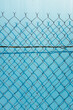 © Rialto Images/Stocksy - Chain link fence in front blue wall