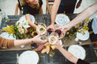 © Kate Daigneault/Stocksy - Group of friends cheersing over dinner.