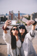© Guille Faingold/Stocksy - two young woman making a selfie with their smartphones