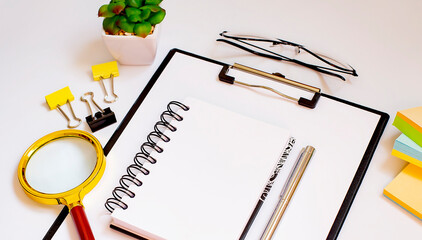 Poster - Topview of white desktop with neatly organized office tools and electronic gadgets and magnifier