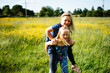 © Helen Rushbrook/Stocksy - 2 little girls giving each other piggy-backs outdoors