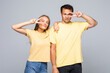 © F8  \ Suport Ukraine - Lovely couple showing peace symbol near their eyes, standing over grey background