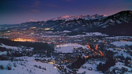 Wall Mural - Sunset over illuminated Zakopane in winter, aerial view