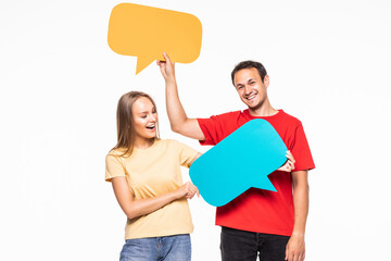 Portrait of a happy young couple holding empty speech bubbles isolated over white background