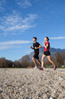 © Alberto Bogo/Stocksy - Couple runs along the beach