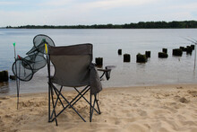 Folding Chair And Fish Tank Stand At The Beach. Fishing Singly.