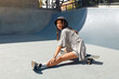 © puhhha - Summer. Skater Girl Sitting On Skateboard At Skatepark Portrait. Female Teenager In Casual Outfit Looking At Camera Against Concrete Wall. Urban Sport As Lifestyle Of Active Teens In City.