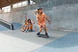 © puhhha - Skateboarding. Man Riding On Skateboard At Skatepark. Group Of Skaters In Casual Outfit Doing Tricks On Concrete Ramp. Summer Activity As Lifestyle. Extreme Sport For Active Urban Guys And Girls.